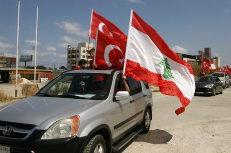 Lebanese supporters and members of the Islamic group Jamaa Islamiya wave Turkish and Lebanese flags during a demonstration to support Turkish President Recep Tayyip Erdogan (portrait) following a deadly but foiled coup attempt by an army faction on July 16, 2016 outside the Islamic Turkish hospital in the southern Lebanese port city of Sidon.  / AFP PHOTO / MAHMOUD ZAYYAT